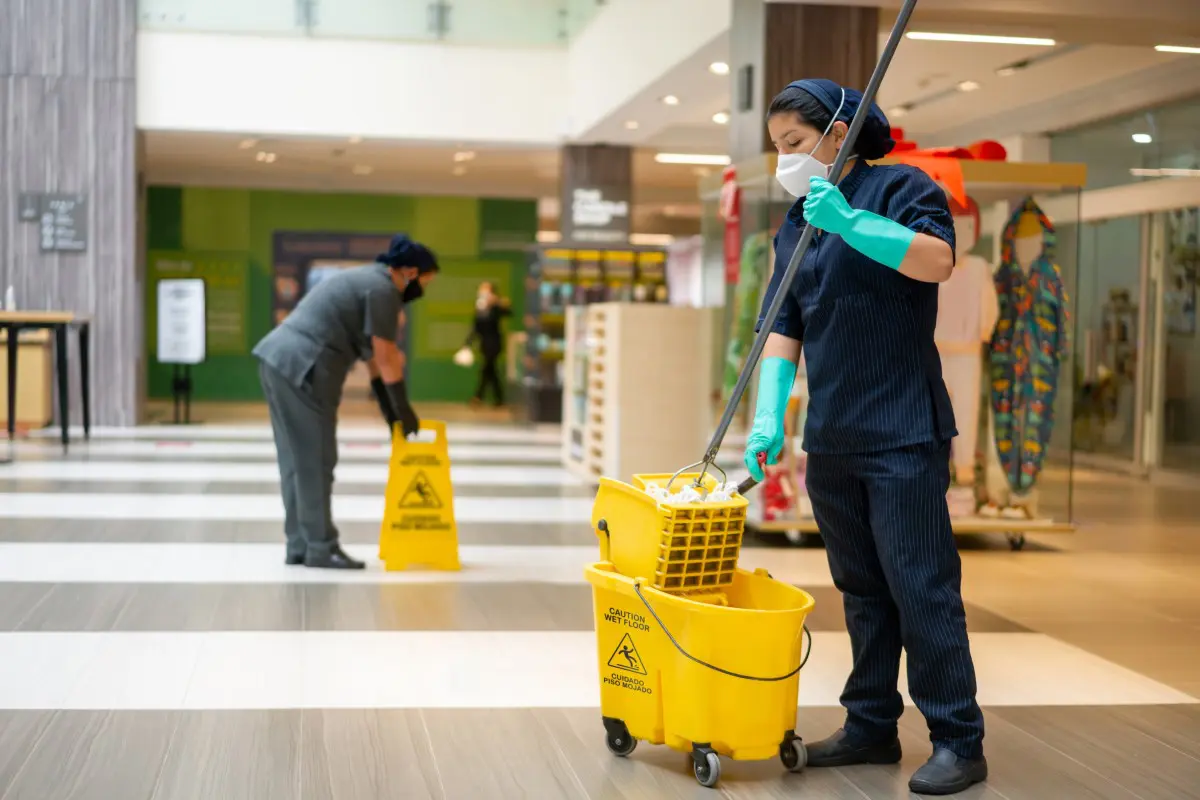 Cleaning staff mopping floors in shopping mall.