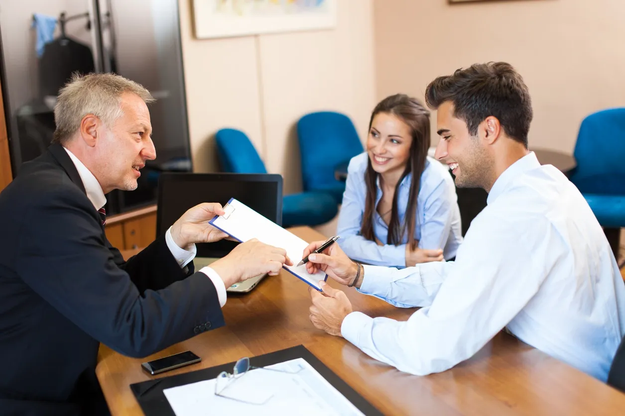 A professional consultation between a couple and an advisor in an office.